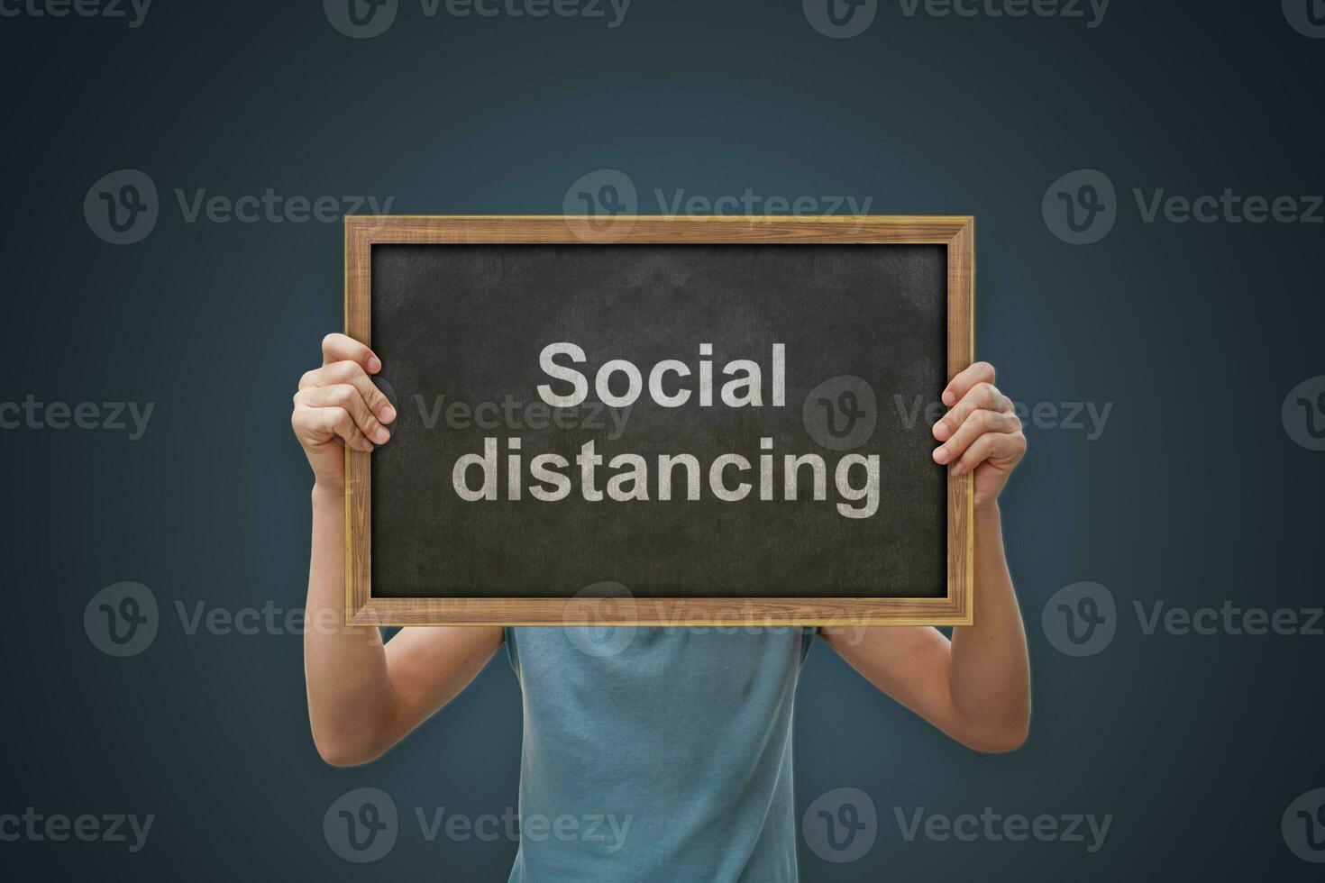 Male hand holding black board sign with text Social distancing. Concept public healthcare and prevent from risk of coronavirus photo