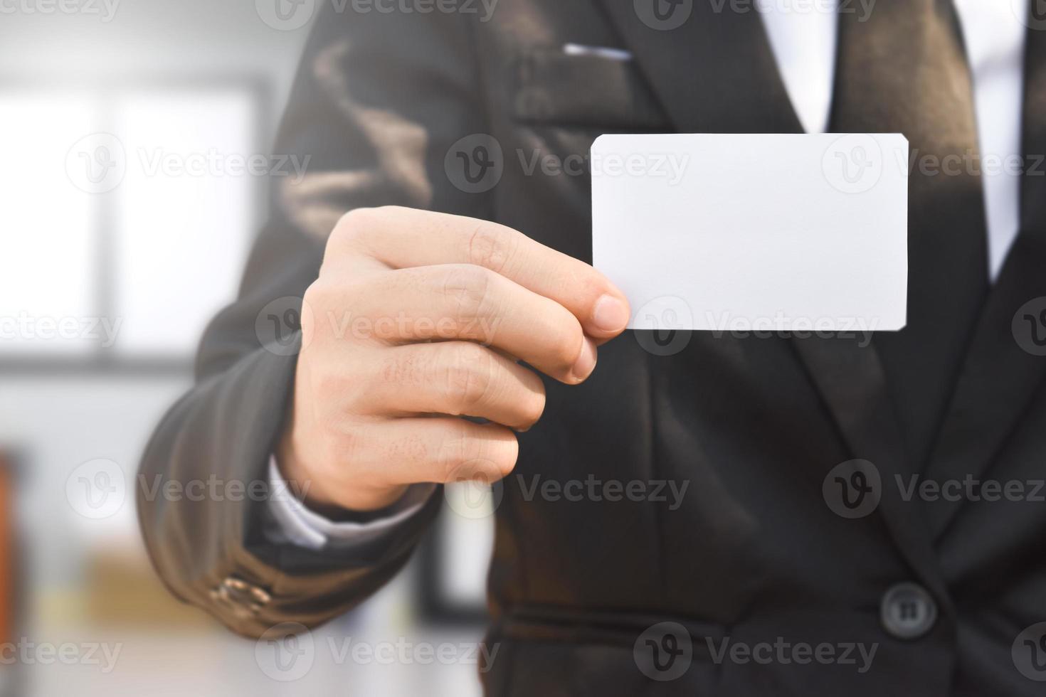 Businessman showing a blank piece of paper. Any business cards design ideas. photo