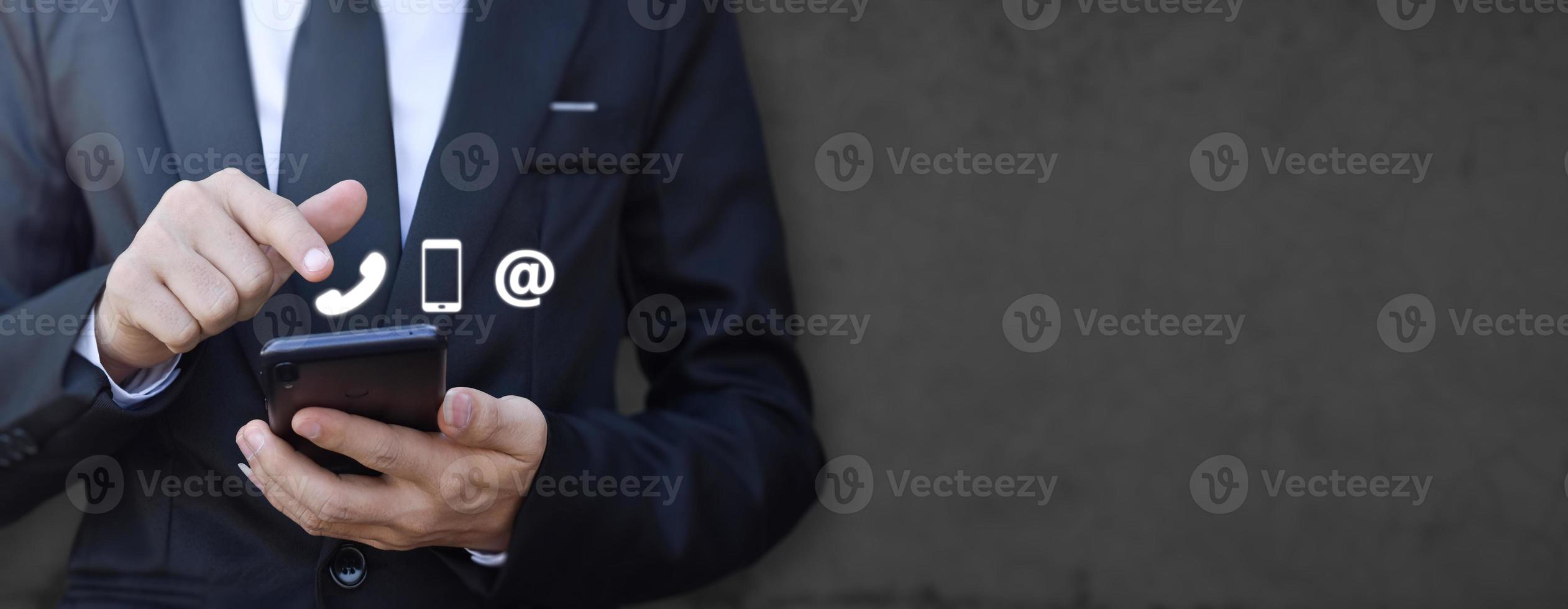 Businessman hand holding smartphone with icon mobile phone, and email address. photo