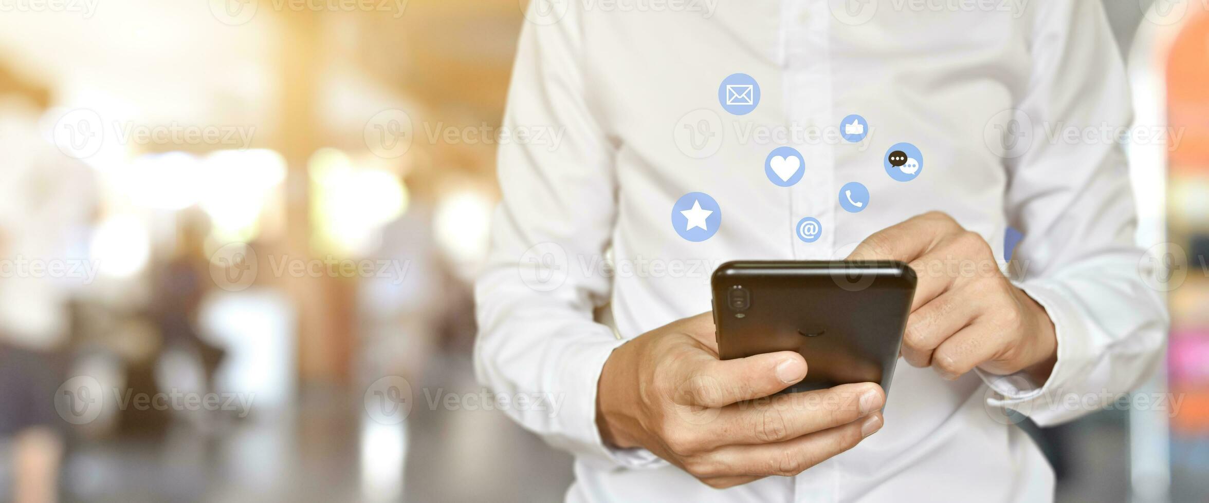 Close up of man using mobile smartphone with social, media icons. Marketing or business technology concept. photo