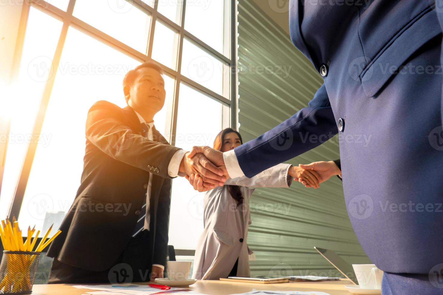 gente de negocios dándose la mano en la oficina moderna terminando una reunión exitosa foto