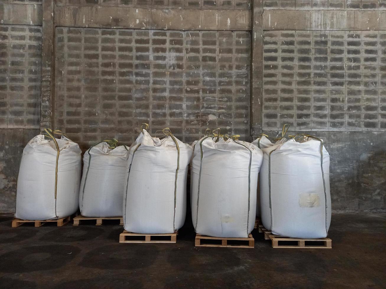 gran saco de cáñamo jumbo blanco, lleno de fertilizante químico, arroz, azúcar, colocado en un palé de madera a la espera de ser entregado al cliente foto