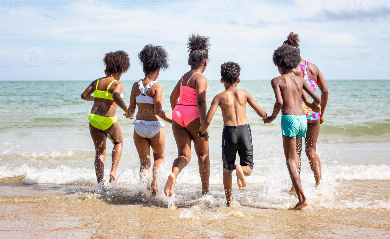 niños jugando corriendo en la arena en la playa foto