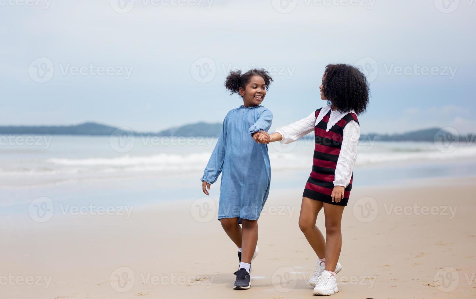 Kids playing running on sand at the beach photo