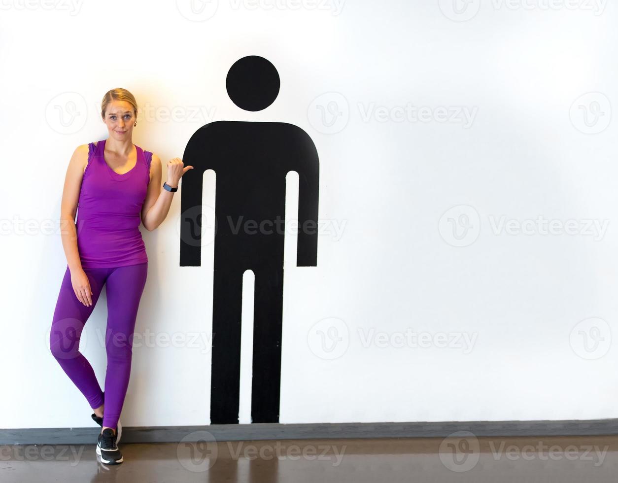 portrait of women with sportwear standing beside men graphic charecter against white wall photo