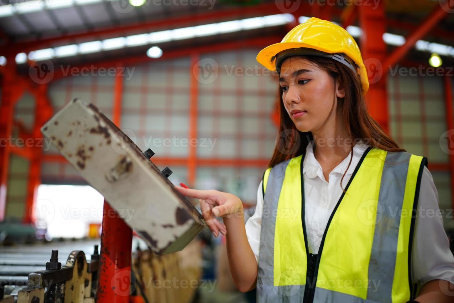 la capataz de la trabajadora o el trabajo del trabajador en el sitio de la fábrica revisan la máquina o los productos en el sitio. ingeniero o técnico revisando material o máquina en planta. industrial y fábrica. foto