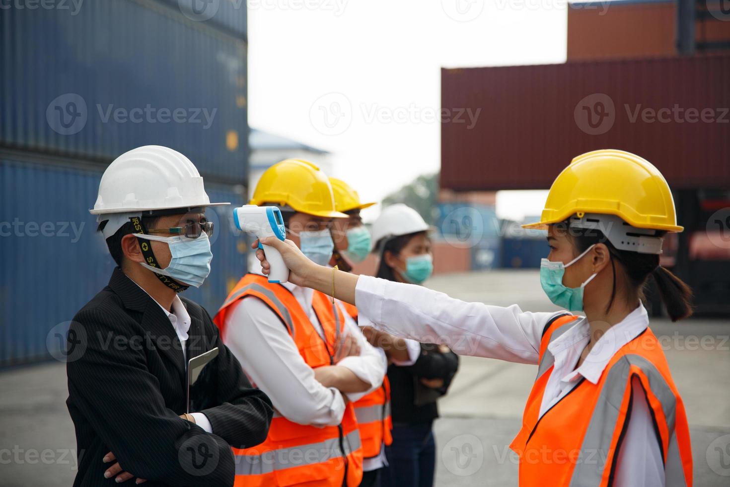 Foreman control loading Containers box from Cargo freight ship for import export. photo