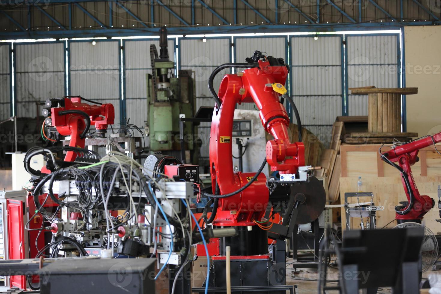Robotics arm in the metal factory plant . it's performing routine servicing of the welding robotics units equipment. photo