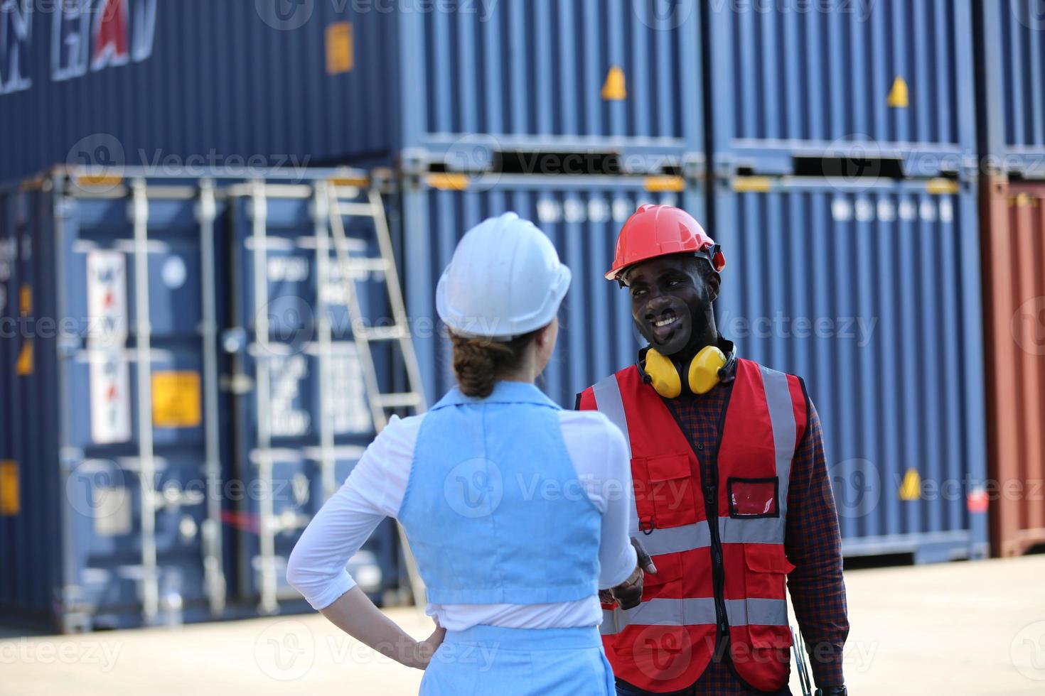 Foreman control loading Containers box from Cargo freight ship for import export. photo