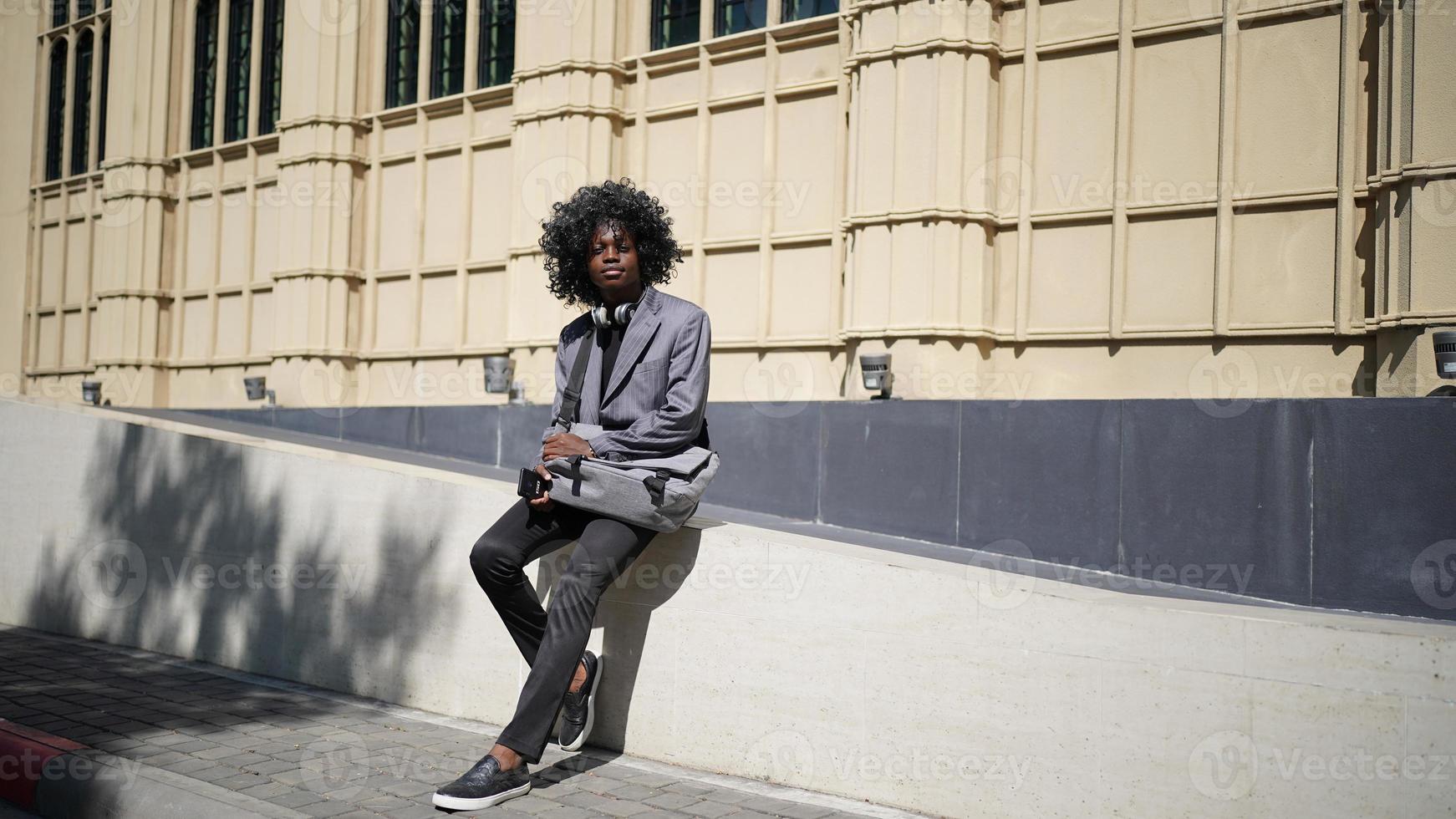 hombre afroamericano divirtiéndose caminando en el centro de la ciudad - joven feliz disfrutando del tiempo una puesta de sol al aire libre - estilo de vida de generación milenaria y concepto de actitud positiva de la gente foto