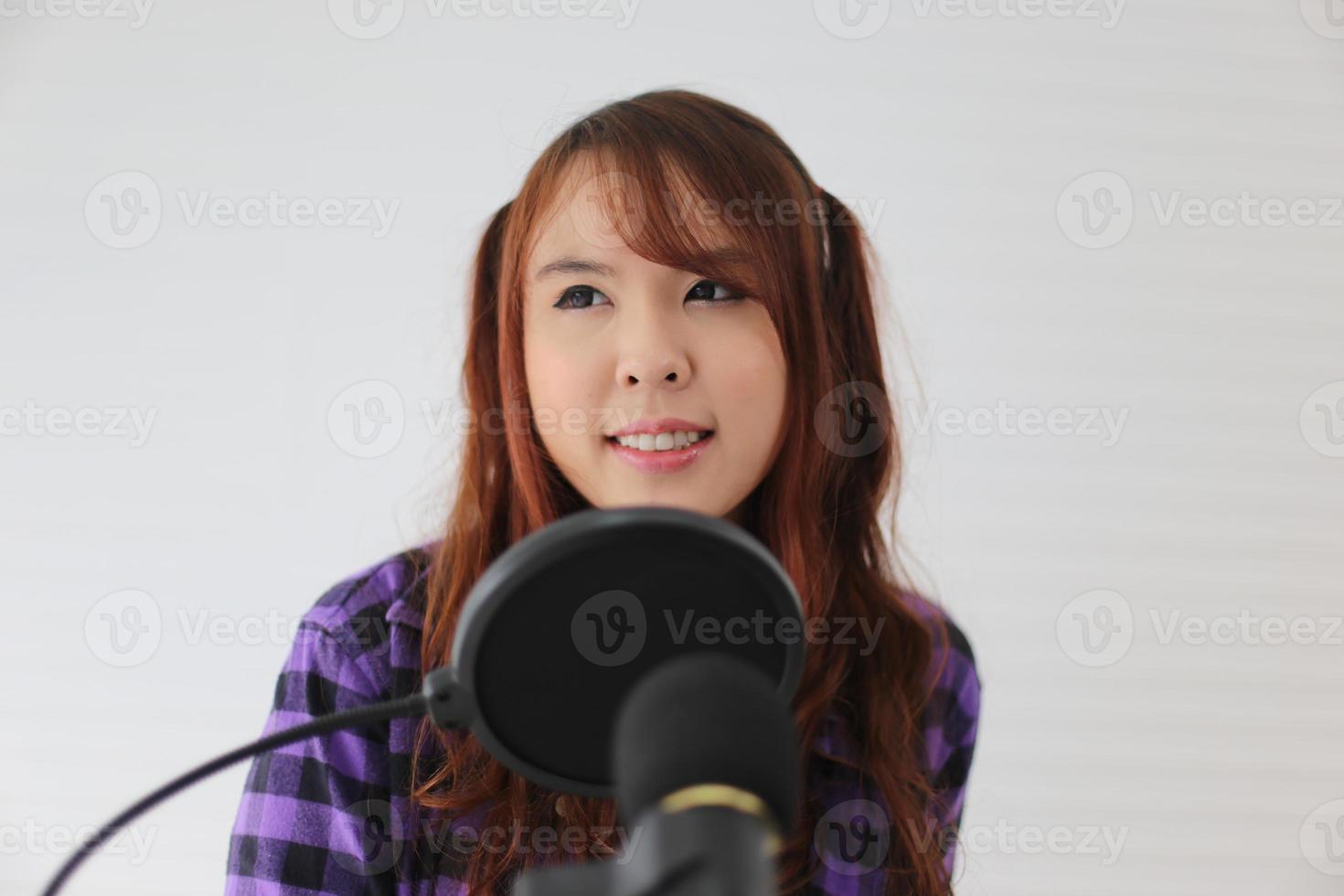 Portrait young woman singing on microphone, closeup shot. photo