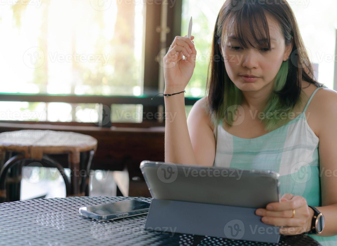 mujer usa tableta para trabajar en línea o trabajar en casa foto