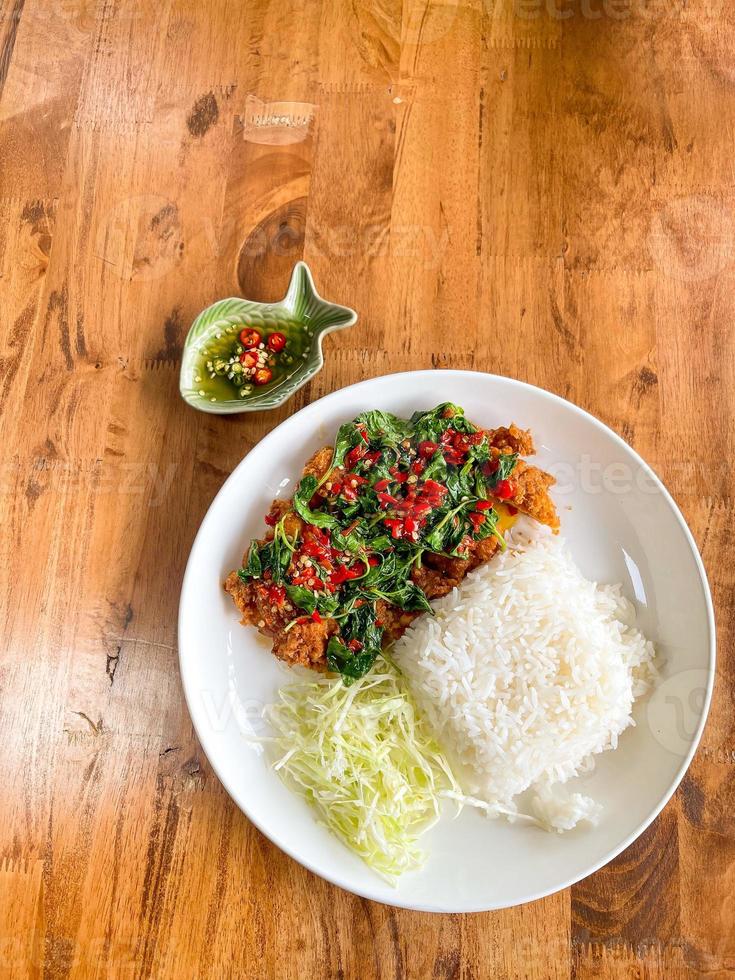 Homemade food, Fried pork cutlet top on stir fried basil, Thai style. photo