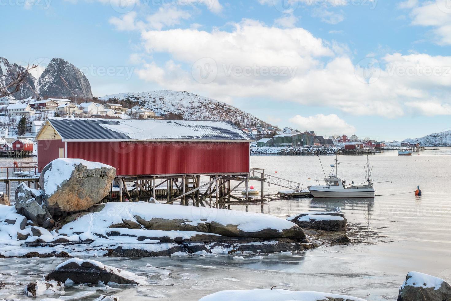 Rorbuer fishing house with boat on coastline on winter season in Lofoten islands photo
