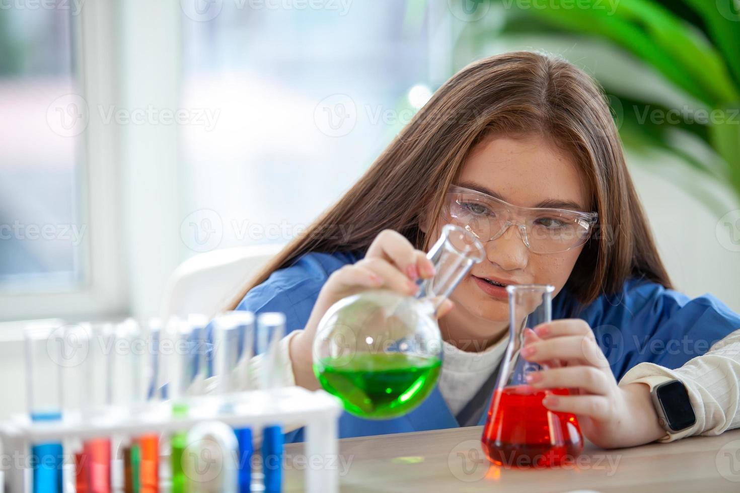 los estudiantes mezclan productos químicos en vasos de precipitados. estudiante de química mezcla productos químicos en la clase de ciencias foto