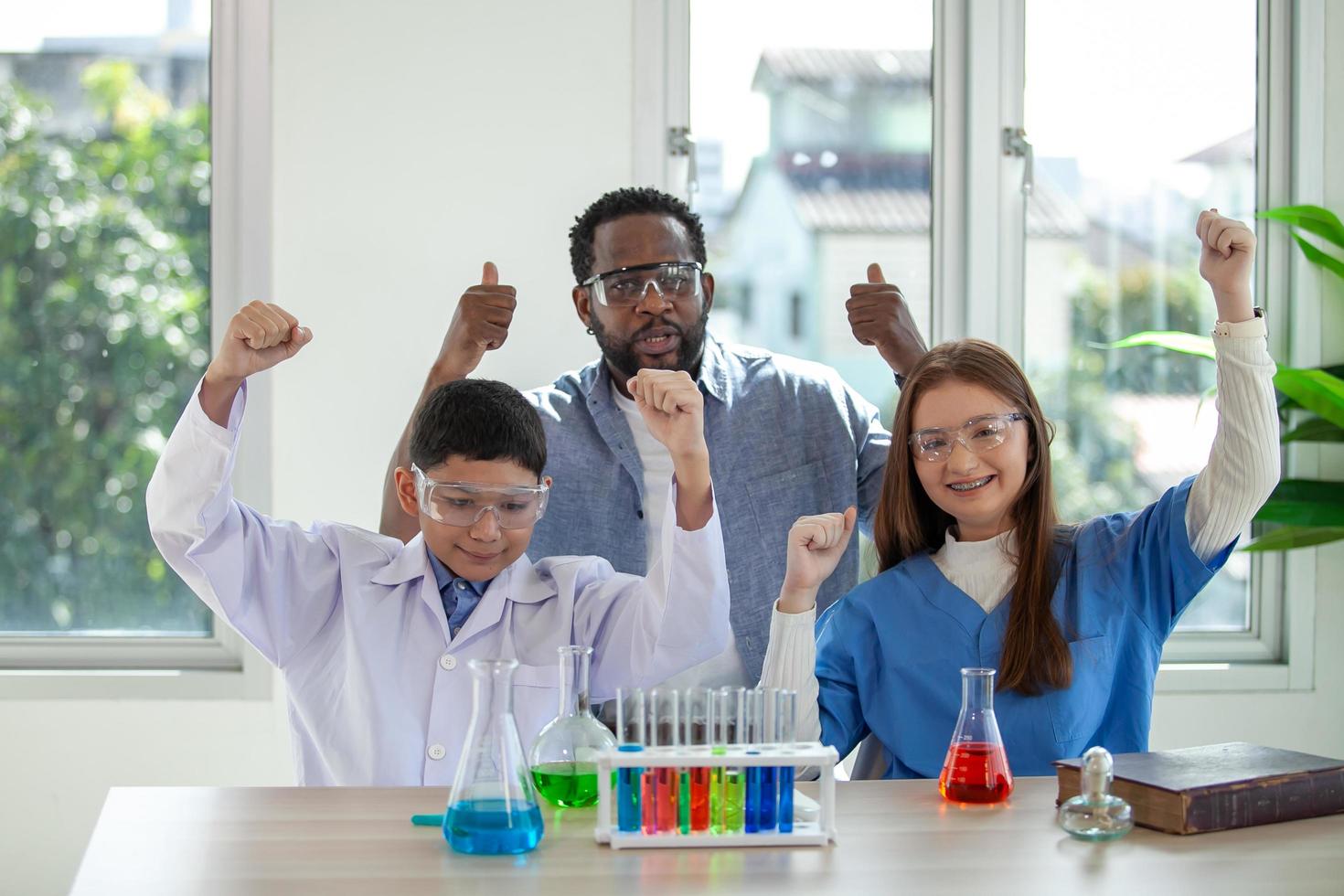 los estudiantes mezclan productos químicos en vasos de precipitados. un profesor entusiasta explica la química a los niños, un estudiante de química muestra un nuevo experimento a la clase de ciencias del profesor foto