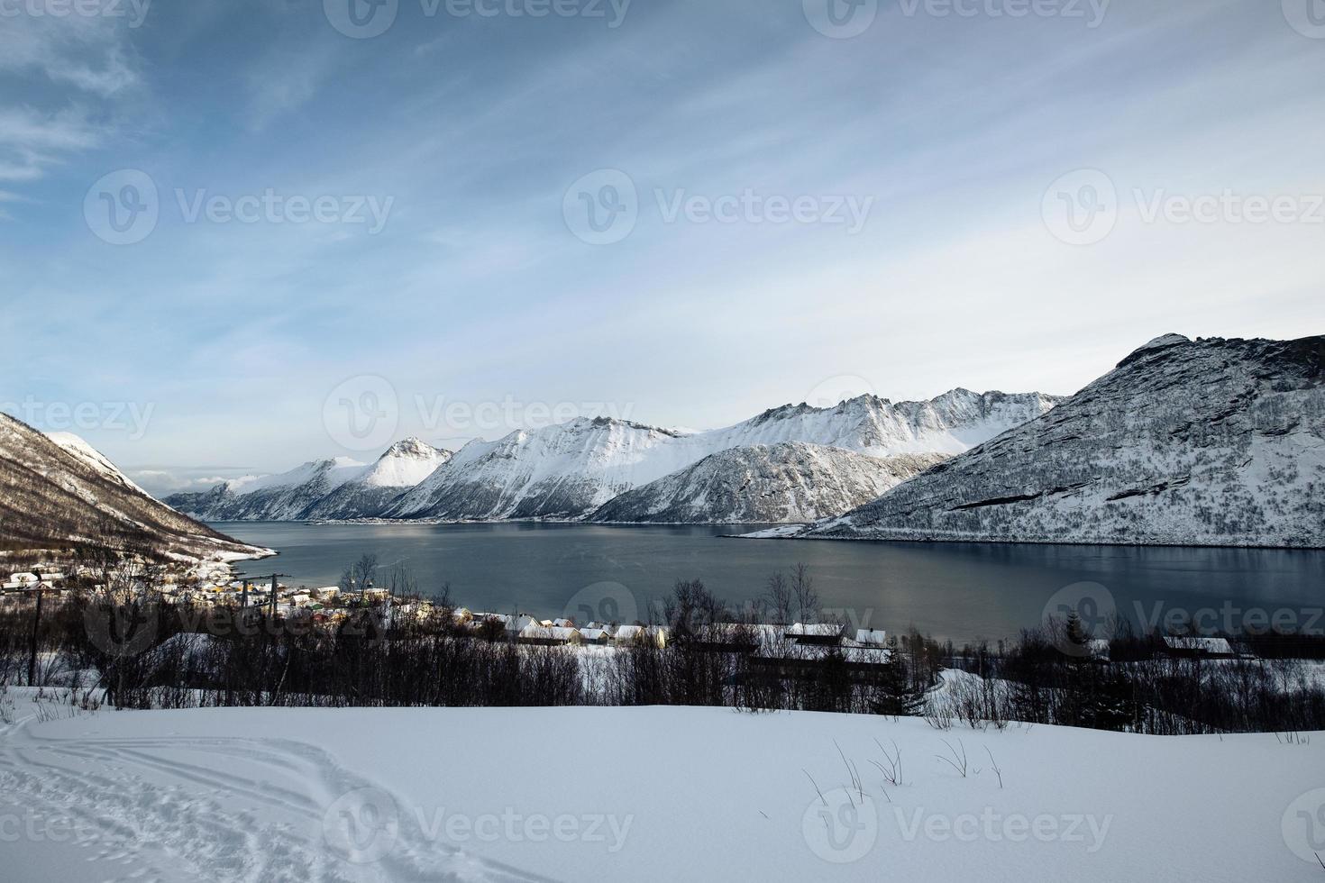 paisaje de la cordillera nevada y el pueblo noruego en la costa en invierno en la isla senja foto