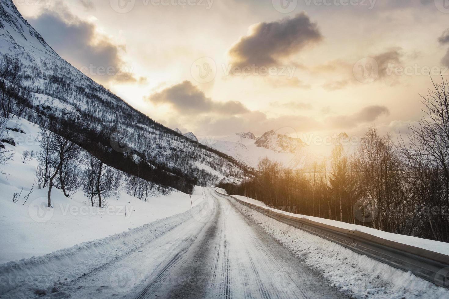 Dirty snow road with sunlight in valley photo