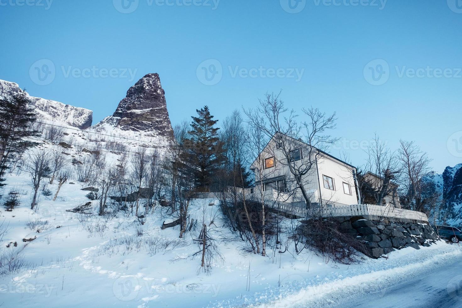 White scandinavian house with famous mountain in winter at Lofoten photo