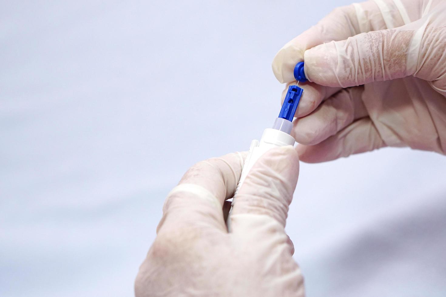 Closeup of doctor hands wear gloves holding syringe for insulin to check blood sugar level by glucose. photo