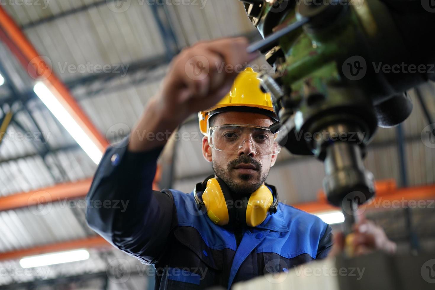 Professional industrial factory employee working with machine part, checking and testing industrial equipment and robot arms in large Electric electronics wire and cable manufacturing plant factory photo