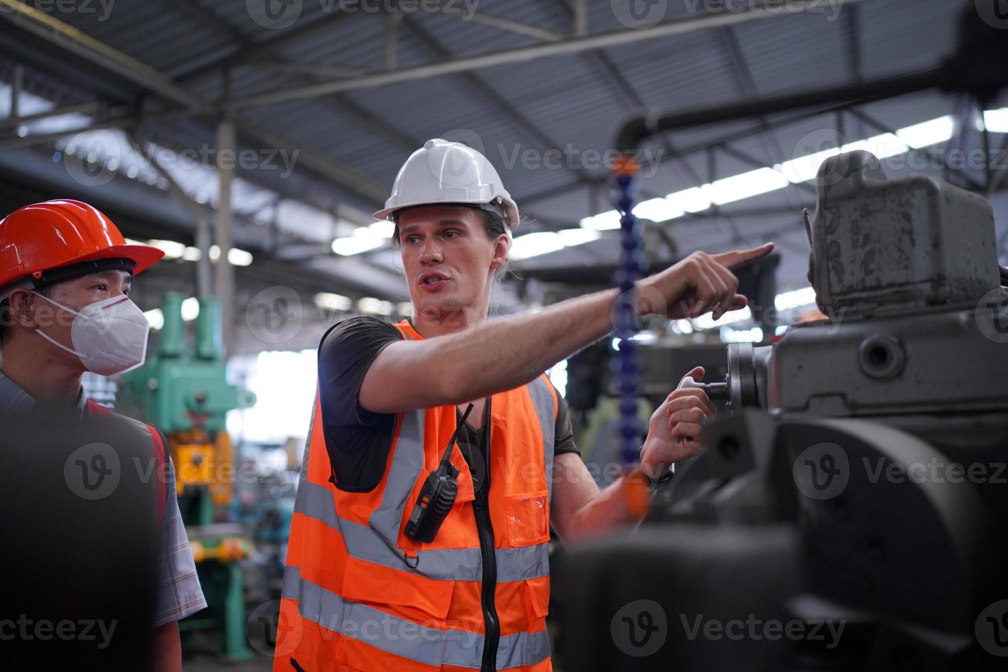 Maintenance Engineers is working in front of the automated CNC machinery repair on a maintenance checklist at the production line. photo