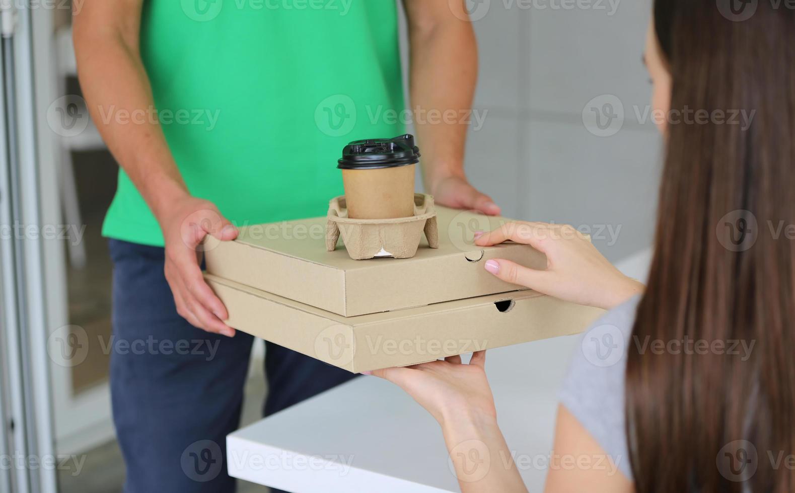 Young man delivered the parcel. Courier with a cardboard box. Parcel Delivery Service. photo