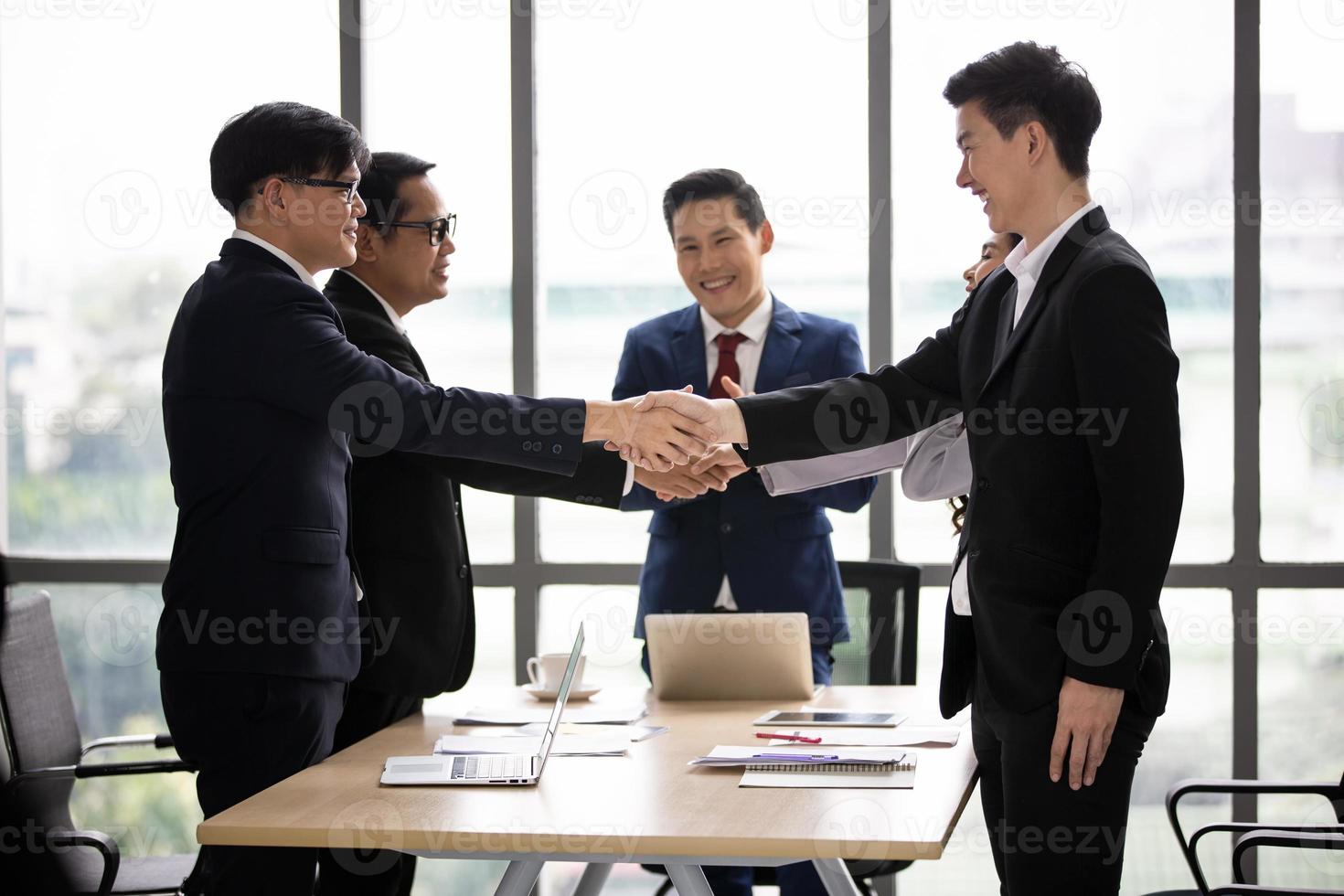 gente de negocios dándose la mano en la oficina moderna terminando una reunión exitosa foto