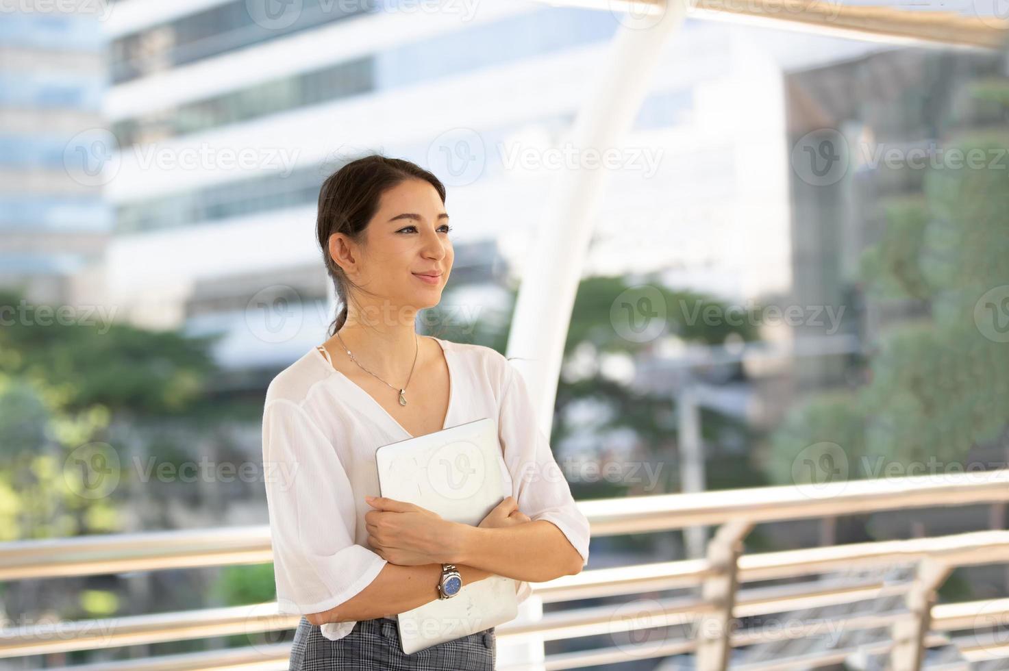 retrato de joven hermosa mujer de negocios en el exterior. brazos cruzados foto