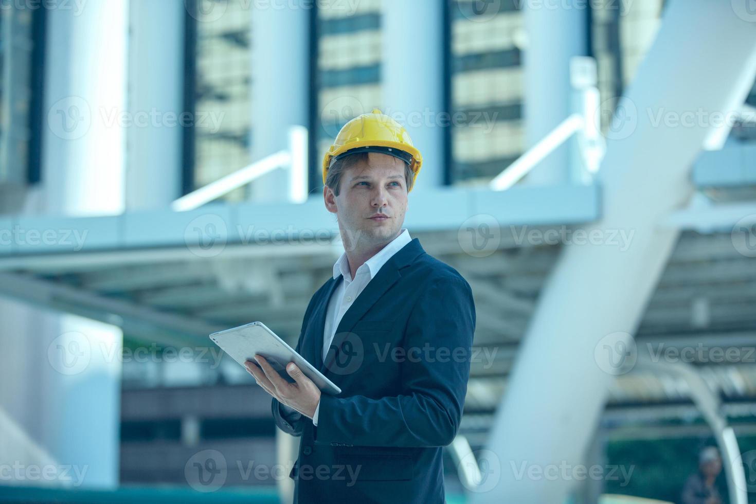 The engineer businessman checking on clipboard at construction site building. The concept of engineering, construction, city life and future. photo