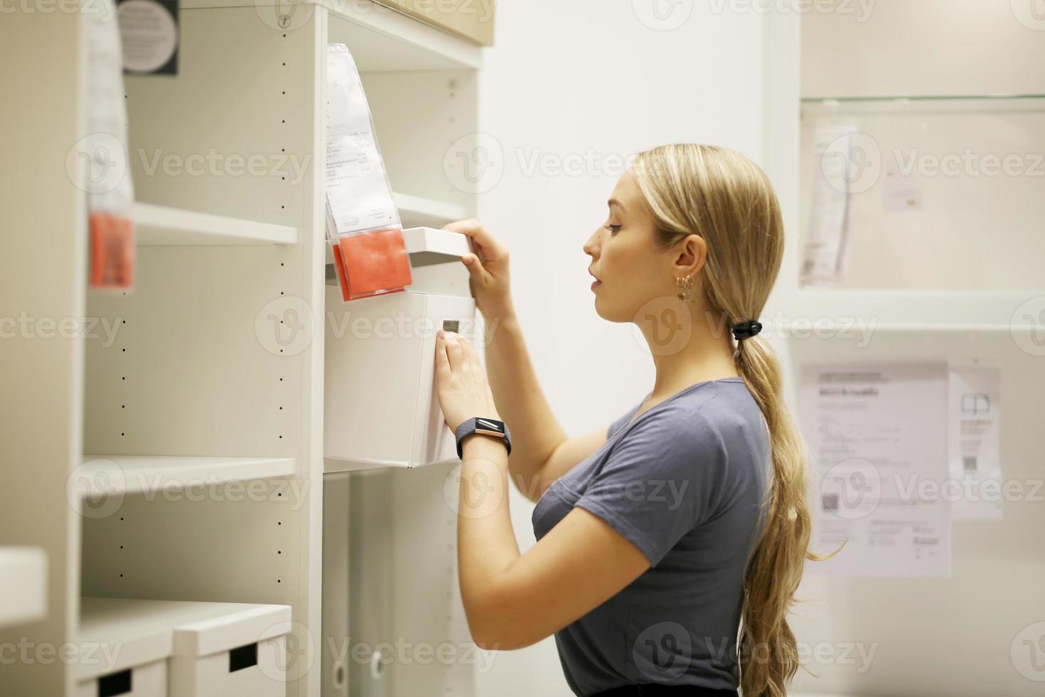 side view of women looking for something on bookshelf photo