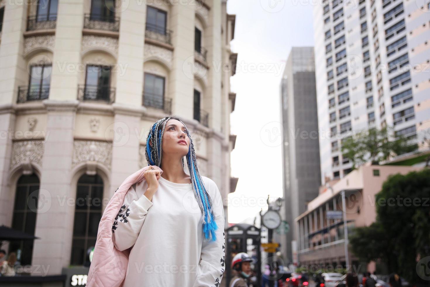 Portrait of Young girl with blue hair, teenage standing on street as urban life. photo