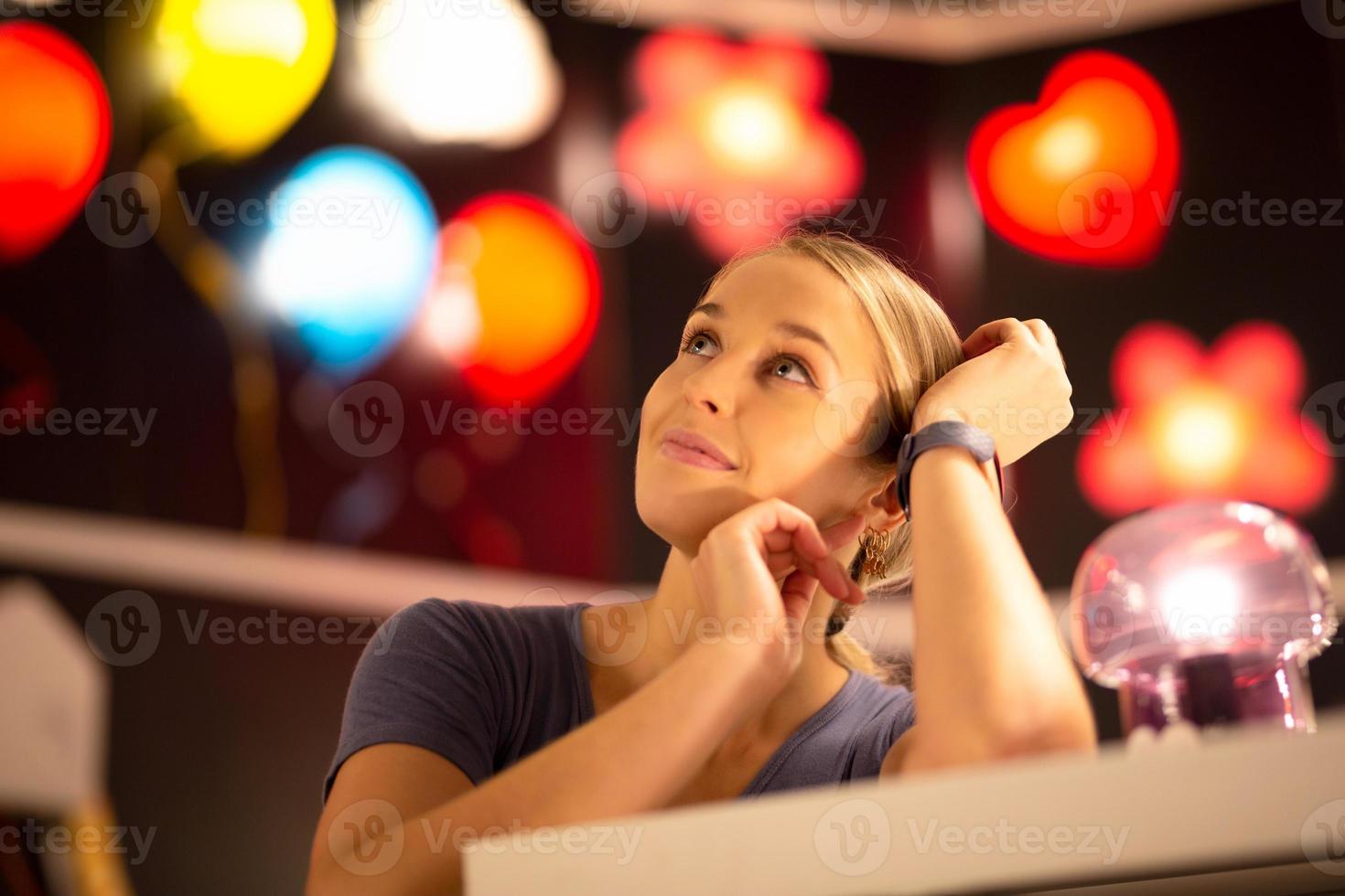 retrato de mujer sonriendo de pie contra la colorida luz bokeh foto