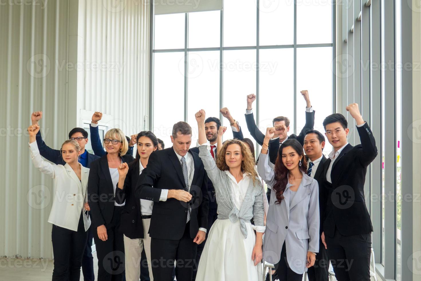 Successful business people standing together widen out showing strong relationship of worker community. A team of businessman and businesswoman expressing a strong group teamwork at the modern office. photo