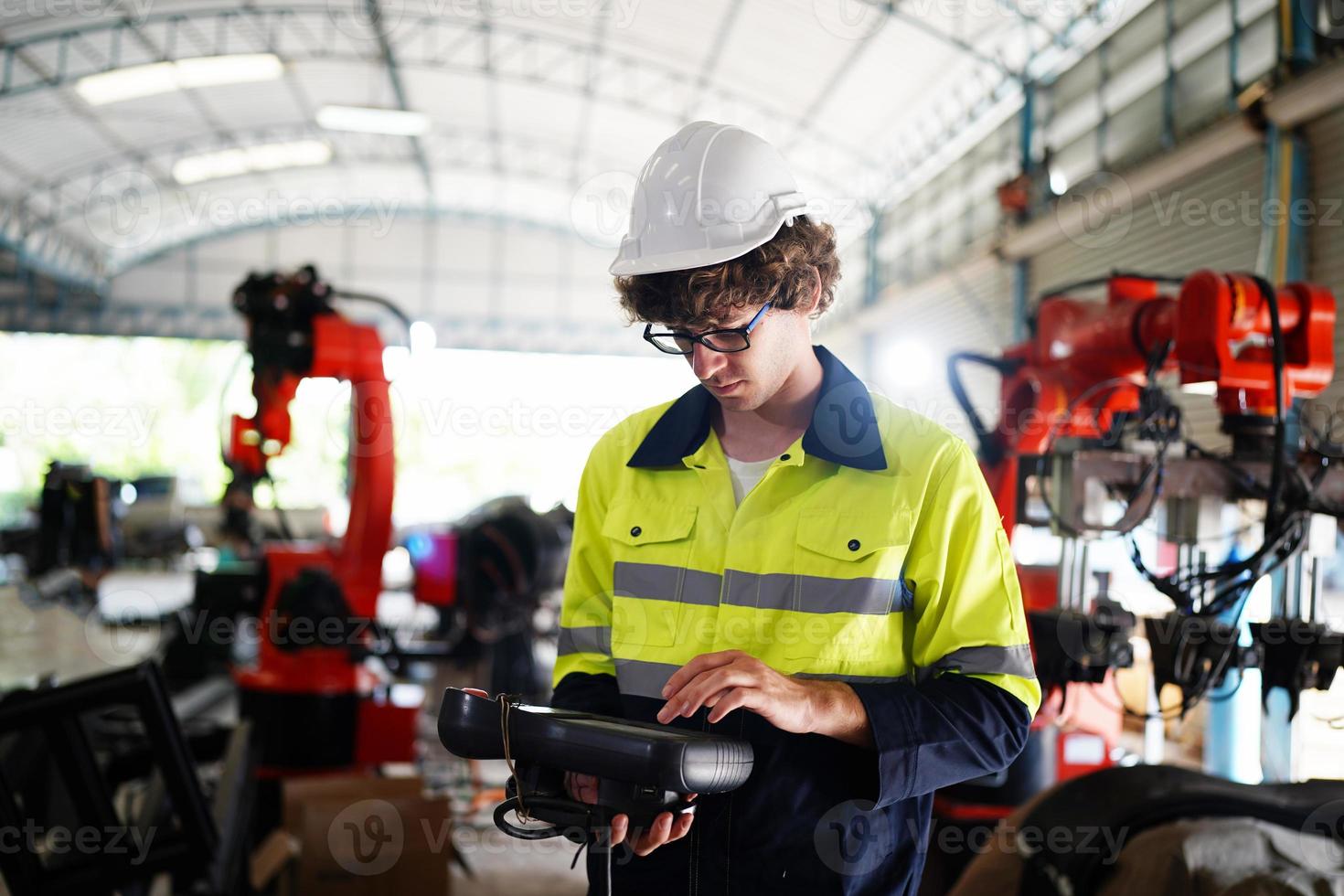 engineer checking control panel and teaching new Automatics robot arm and operating control machine in factory. photo