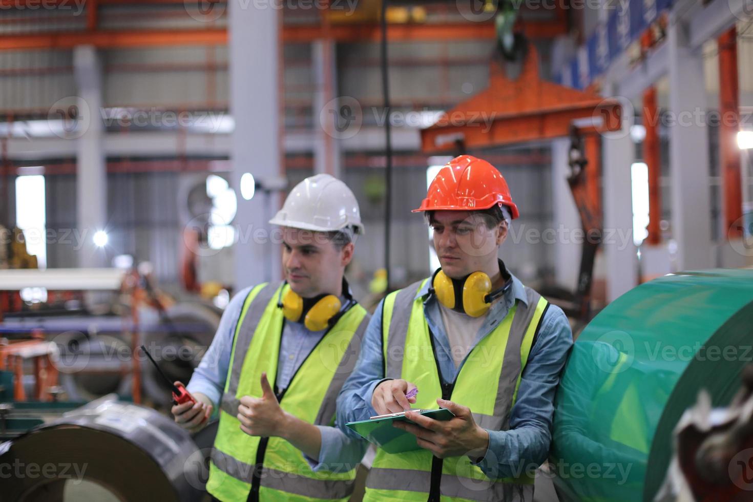 el capataz de los trabajadores de la industria o el trabajo de los trabajadores en el sitio de la fábrica revisan la máquina o los productos en el sitio. ingeniero o técnico revisando material o máquina en planta. industrial y fábrica. foto