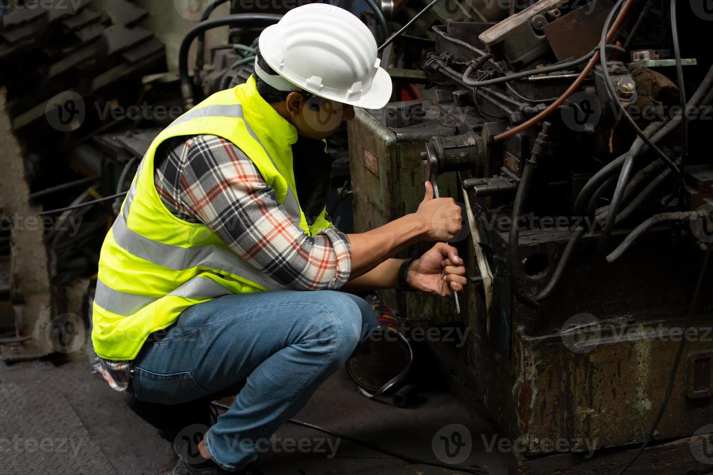 el capataz o el trabajo del trabajador en el sitio de la fábrica revisan la máquina o los productos en el sitio. ingeniero o técnico revisando material o máquina en planta. industrial y fábrica. foto