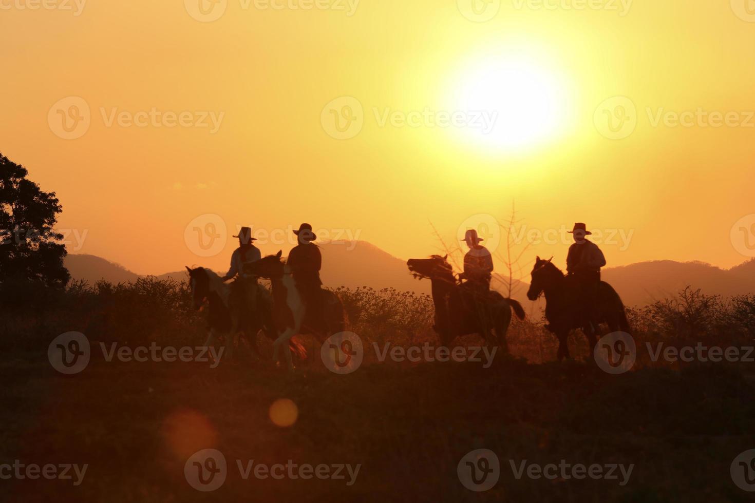 Silhouette Cowboy on horseback against a beautiful sunset, cowboy and horse at first light, mountain, river and lifestyle with natural light background photo