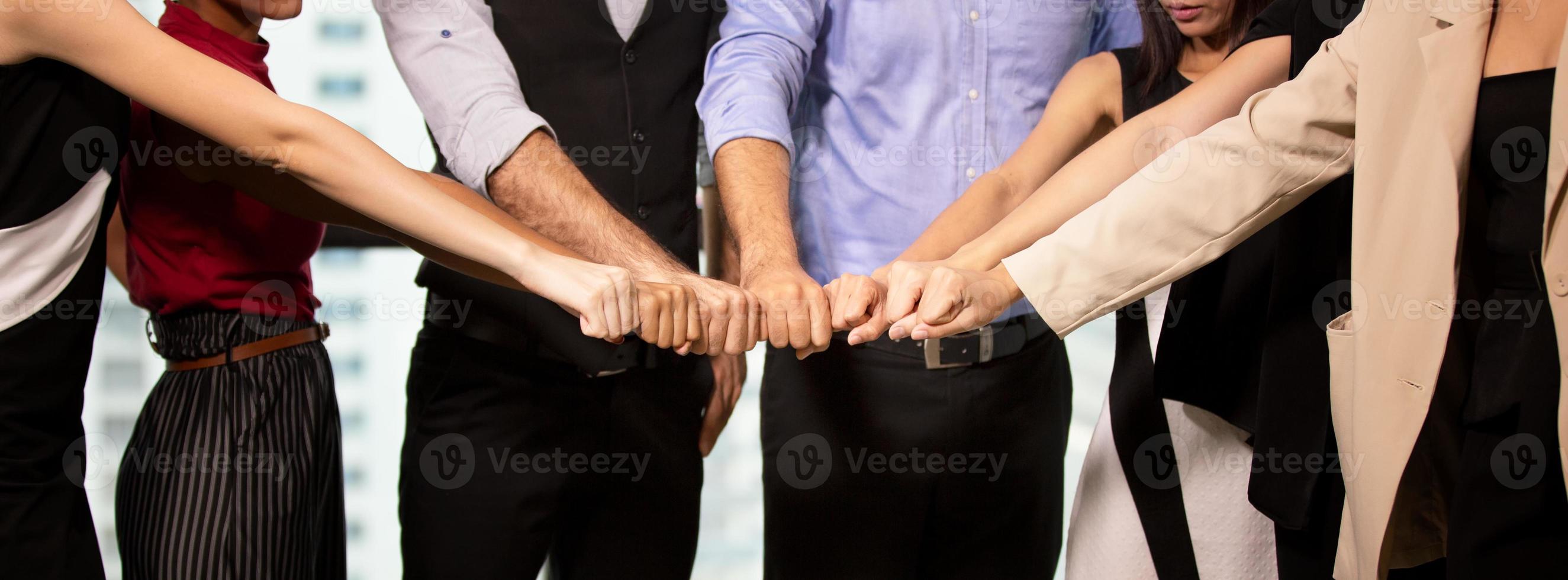 los empresarios exitosos que se unen se ensanchan mostrando una fuerte relación de comunidad de trabajadores. un equipo de hombres de negocios y mujeres de negocios que expresan un sólido trabajo en equipo en la oficina moderna. foto