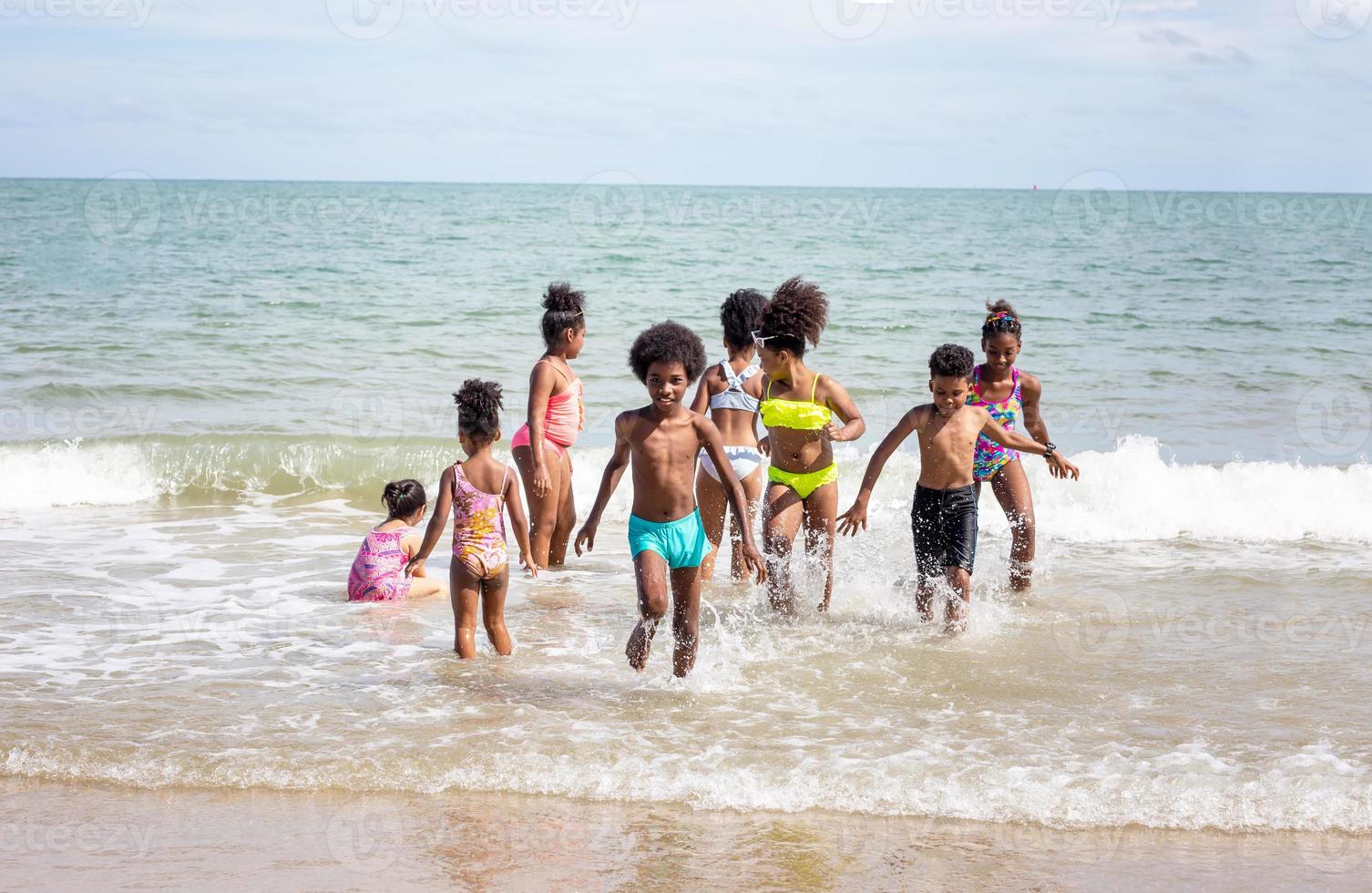 Kids playing running on sand at the beach photo