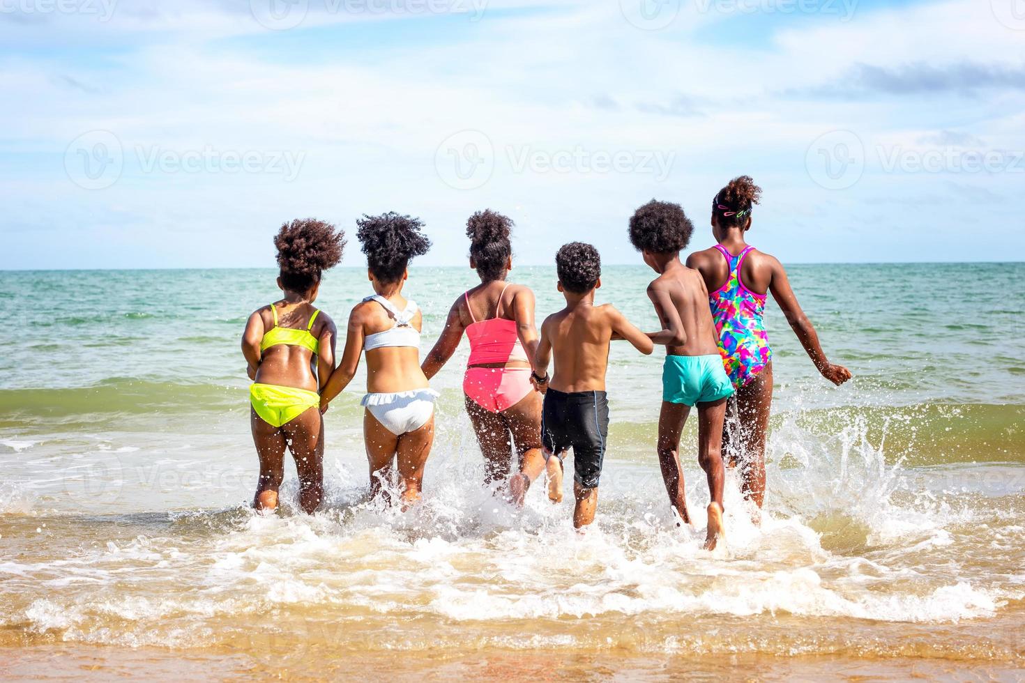 Kids playing running on sand at the beach photo