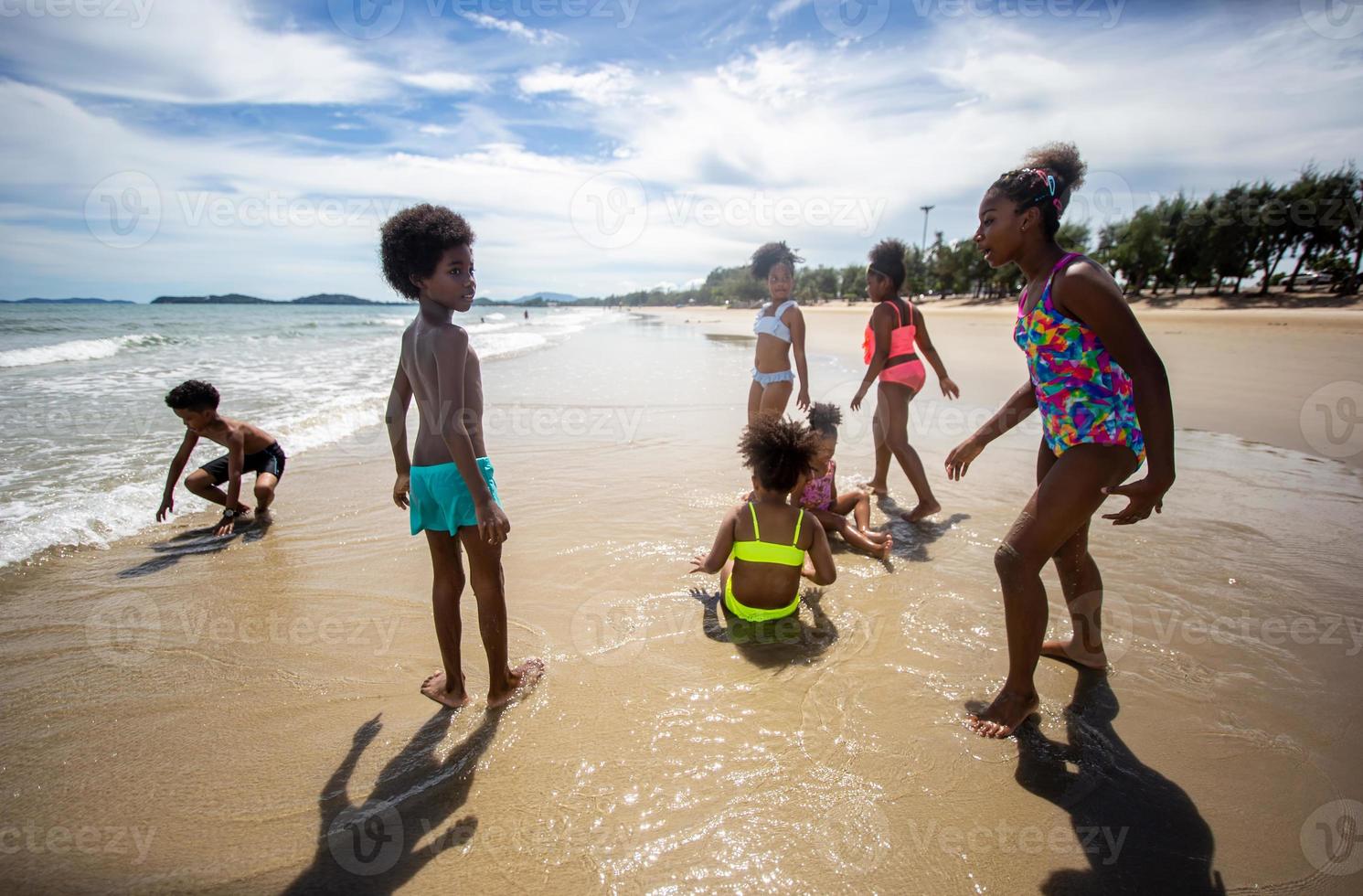 Kids playing running on sand at the beach photo