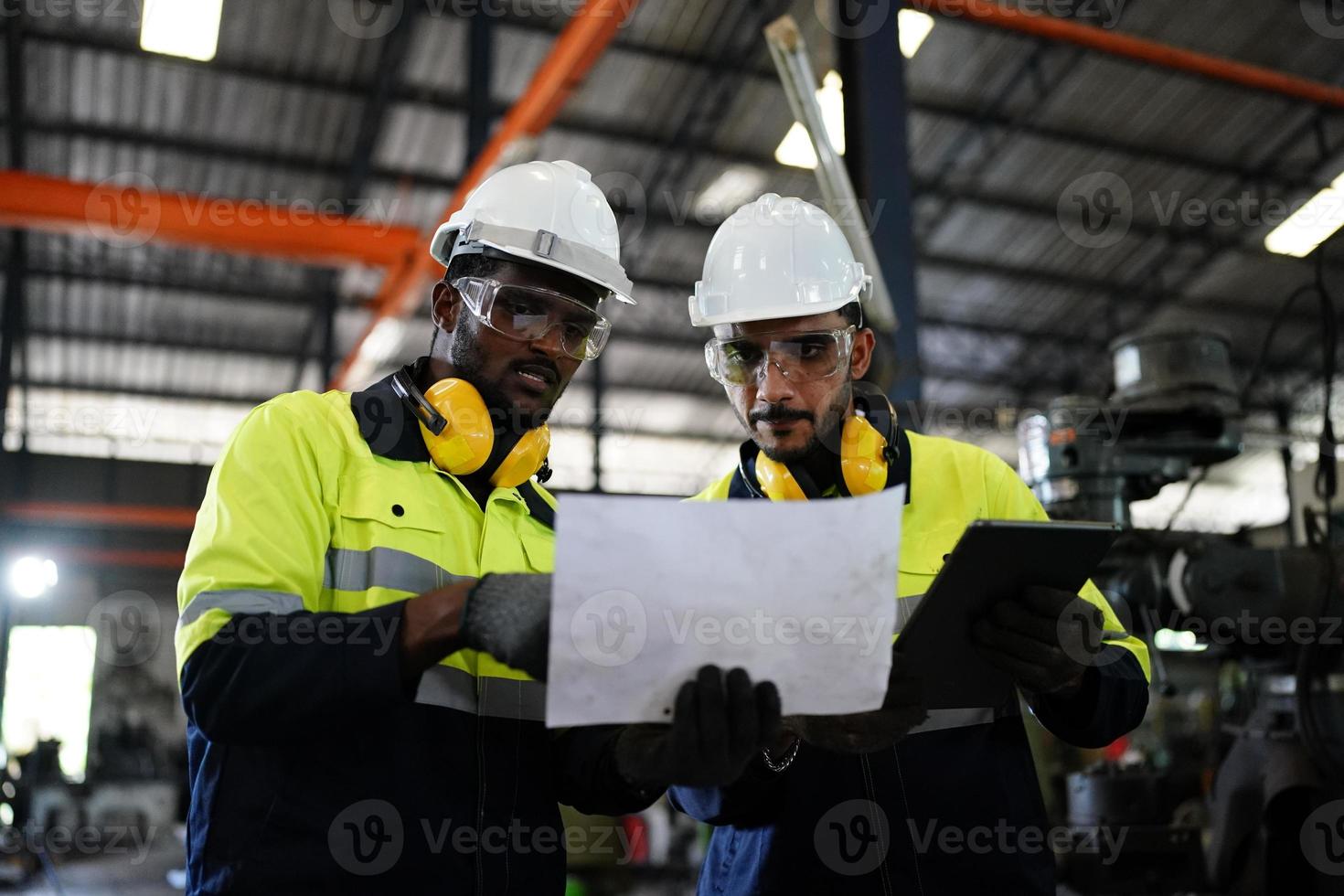 Maintenance Engineers is working in front of the automated CNC machinery repair on a maintenance checklist at the production line. photo