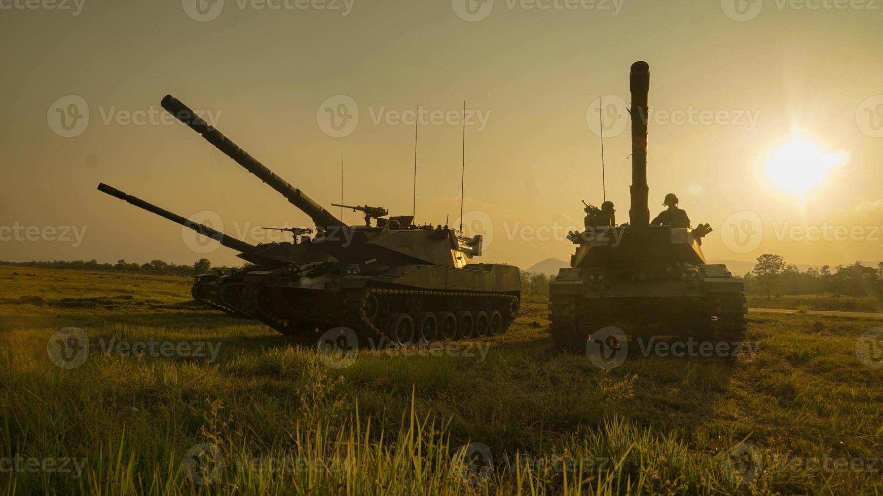 Silhouettes of army soldiers in the fog against a sunset, marines team in action, surrounded fire and smoke, shooting with assault rifle and machine gun, attacking enemy photo