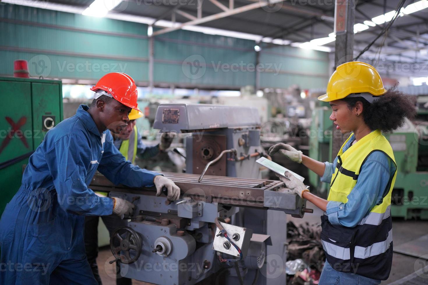 los ingenieros de mantenimiento están trabajando frente a la reparación automatizada de maquinaria cnc en una lista de verificación de mantenimiento en la línea de producción. foto