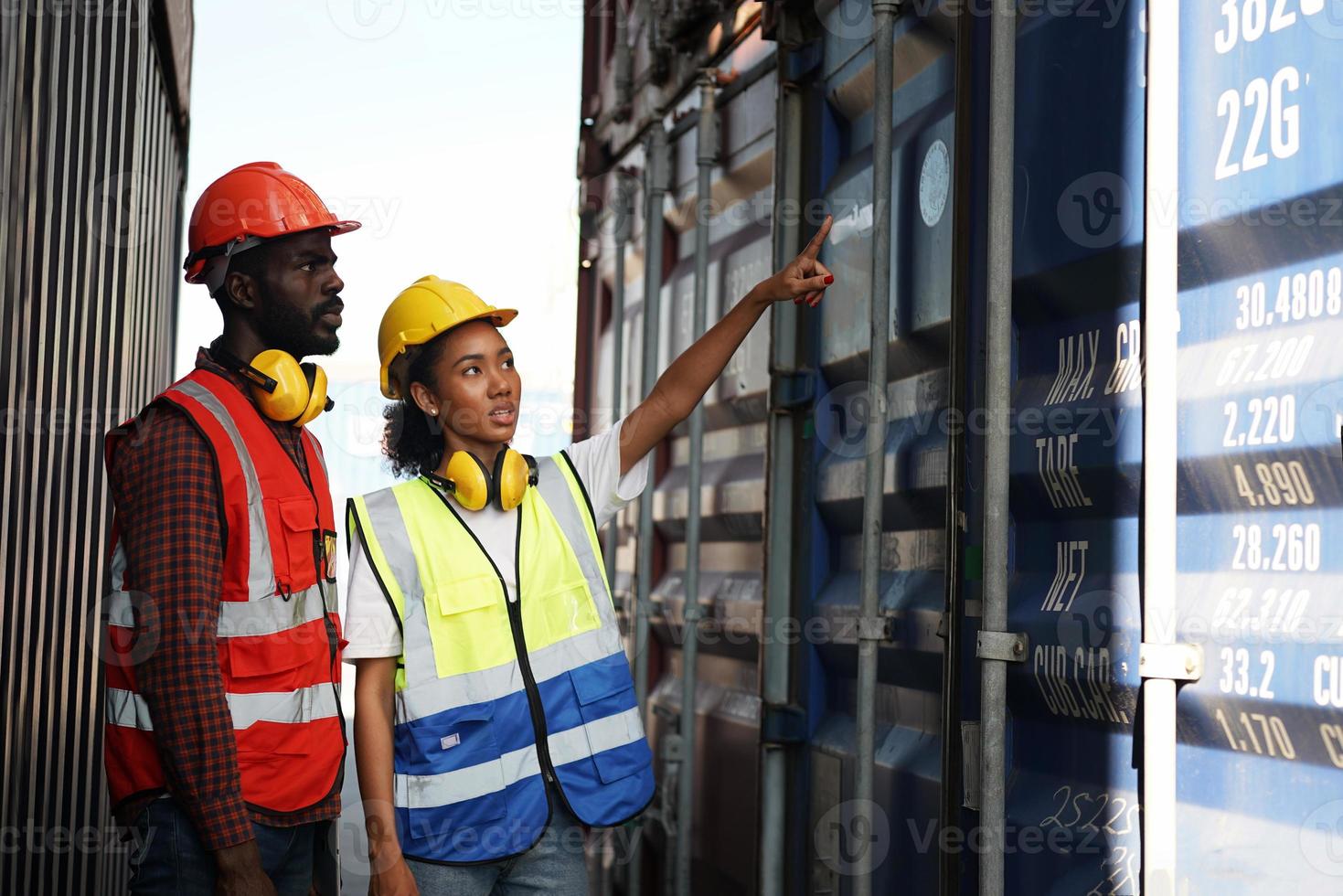 Foreman control loading Containers box from Cargo freight ship for import export. photo