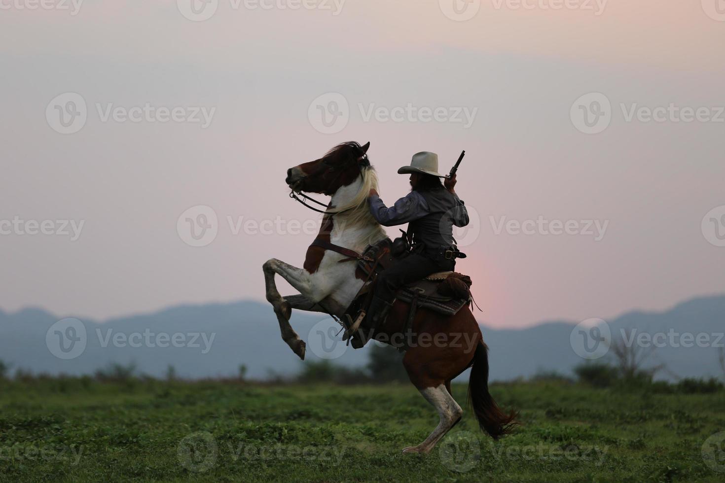 Silhouette Cowboy on horseback against a beautiful sunset, cowboy and horse at first light, mountain, river and lifestyle with natural light background photo