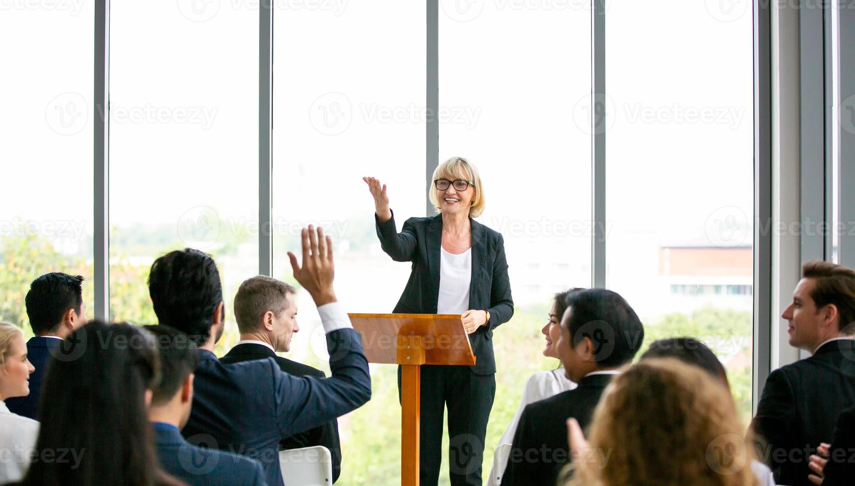 Group of people listening to experienced business professional helping them work out new corporate strategy. photo