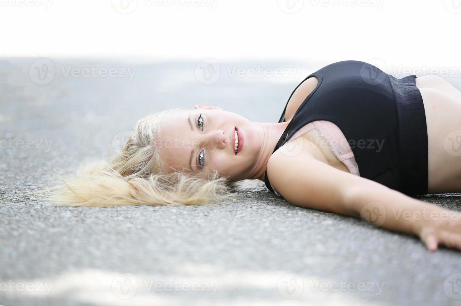 Portrait head shot Of Young Woman lying on street and look at camera. photo