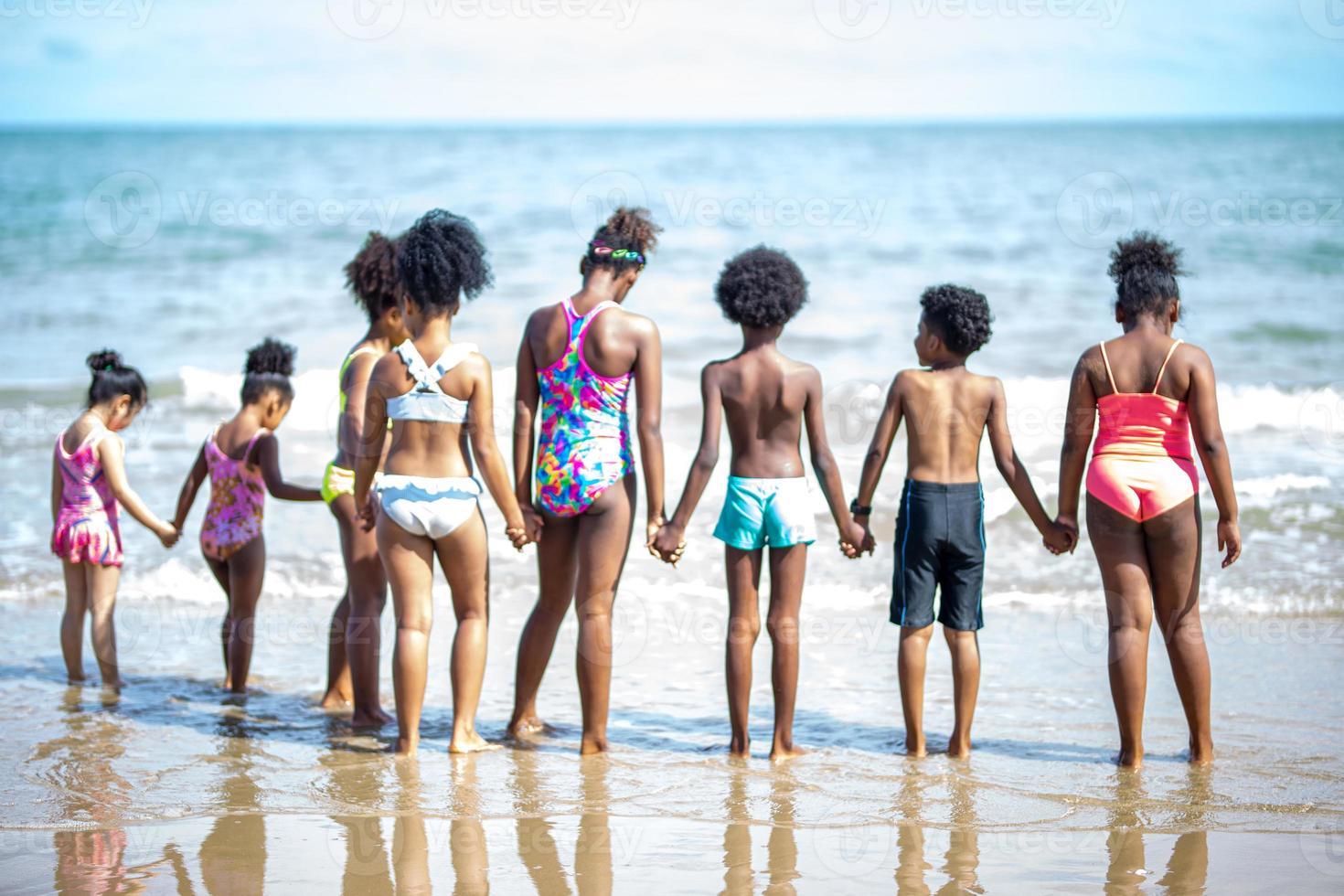 Kids playing running on sand at the beach photo
